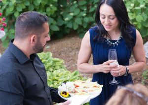 Staff serving appetizers in the garden at a Maison in home party