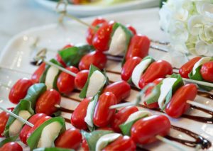Mozzarella, tomato and basil skewers with a balsamic drizzle ready to be served at a Maison in home party